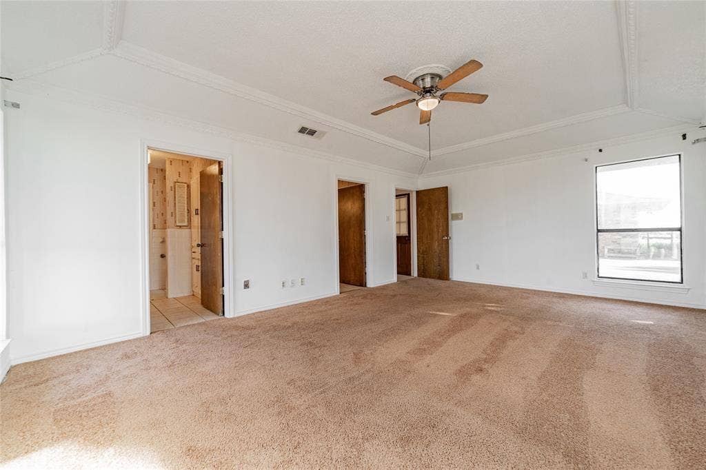 4320 Hickox Road, Rowlett, TX 75089 Tray ceiling with crown molding, ceiling fan, and carpeted flooring
