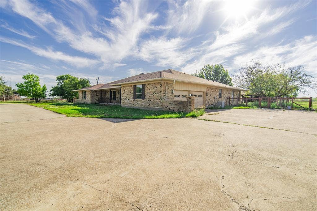 4320 Hickox Road, Rowlett, TX 75089 Brick exterior residence featuring a two-car garage, concrete driveway, and a fenced perimeter