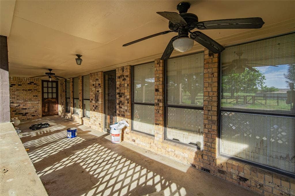 4320 Hickox Road, Rowlett, TX 75089 Covered patio with brick wall facade, integrated ceiling fans, and concrete flooring