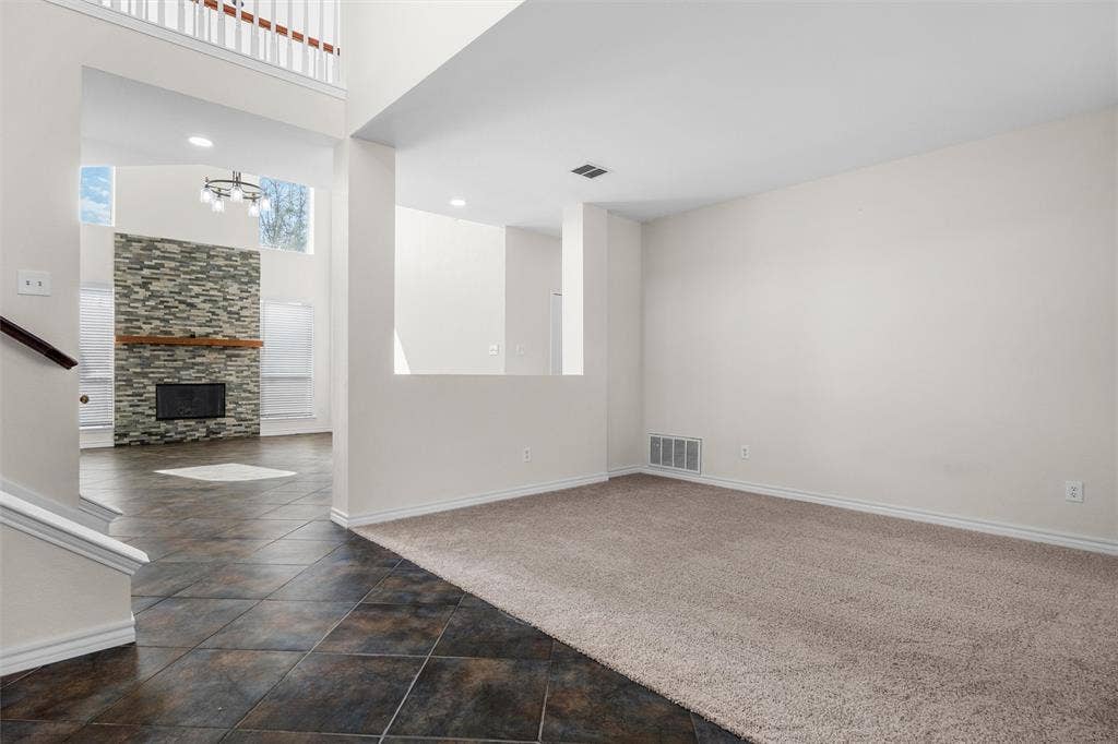 Two-story interior with a stone-clad fireplace and wood mantel