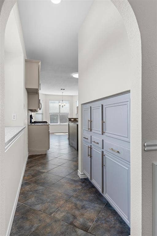 Archway entry featuring built-in cabinetry, tile flooring, and recessed lighting