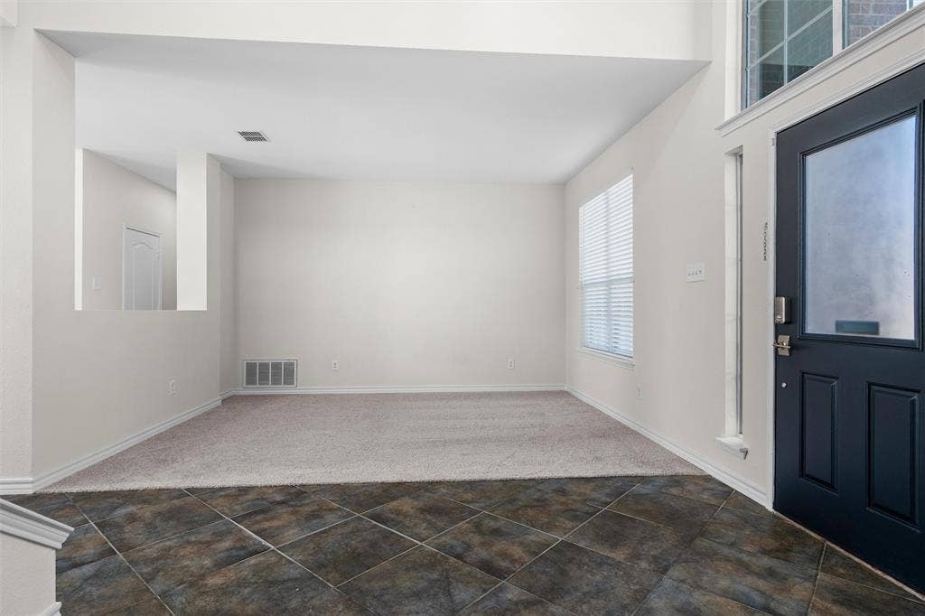 Two-story entry foyer with dark-toned tile flooring
