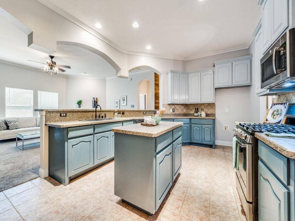 5604 Parkplace Drive, Denton, TX 76226 Kitchen featuring blue cabinetry, a central island, stainless steel appliances, and tile flooring
