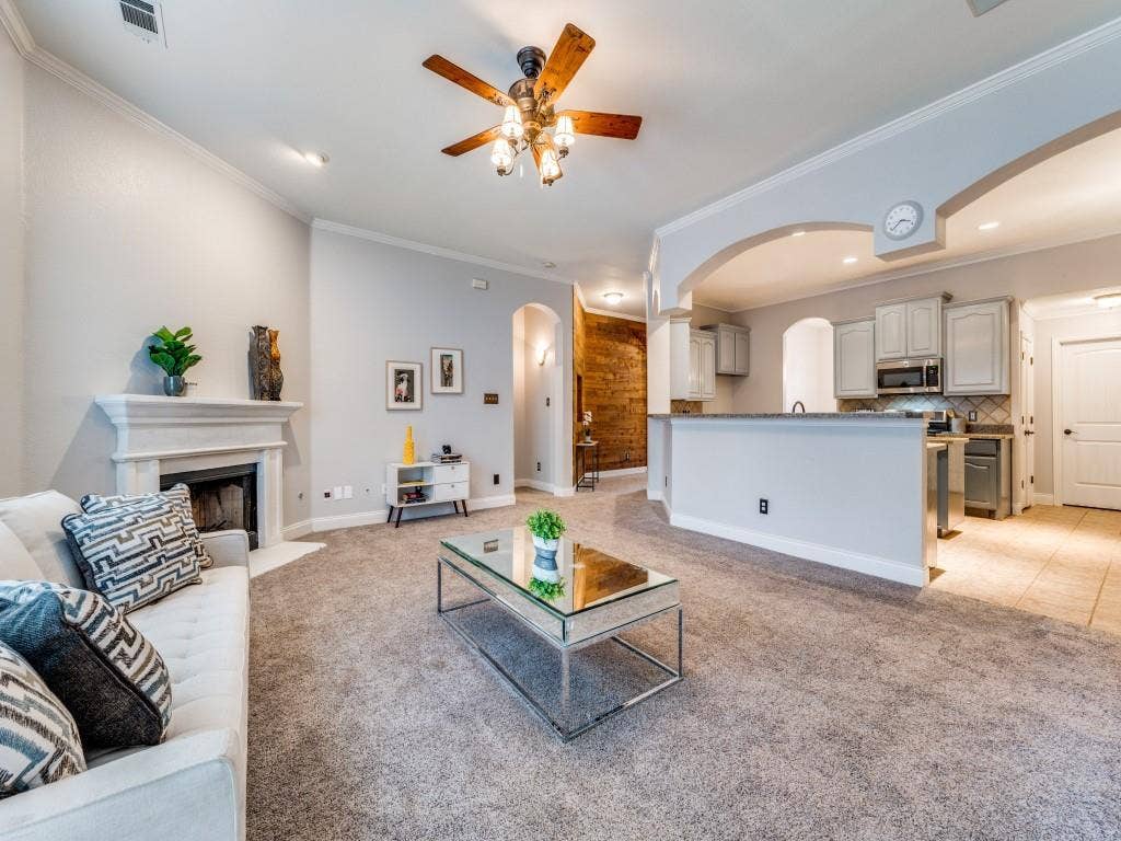 5604 Parkplace Drive, Denton, TX 76226 Living area featuring a fireplace with a mantel, crown molding, and a ceiling fan