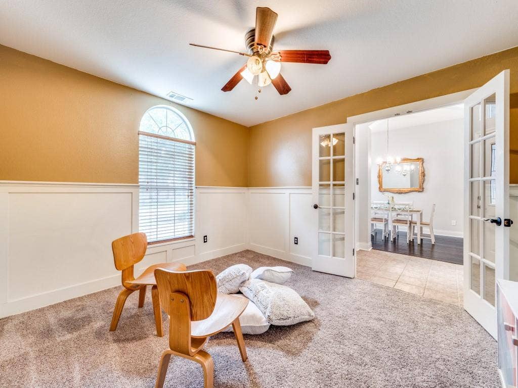 5604 Parkplace Drive, Denton, TX 76226 Arched window with blinds, ceiling fan, carpet flooring, wainscoting, and French doors with glass panels