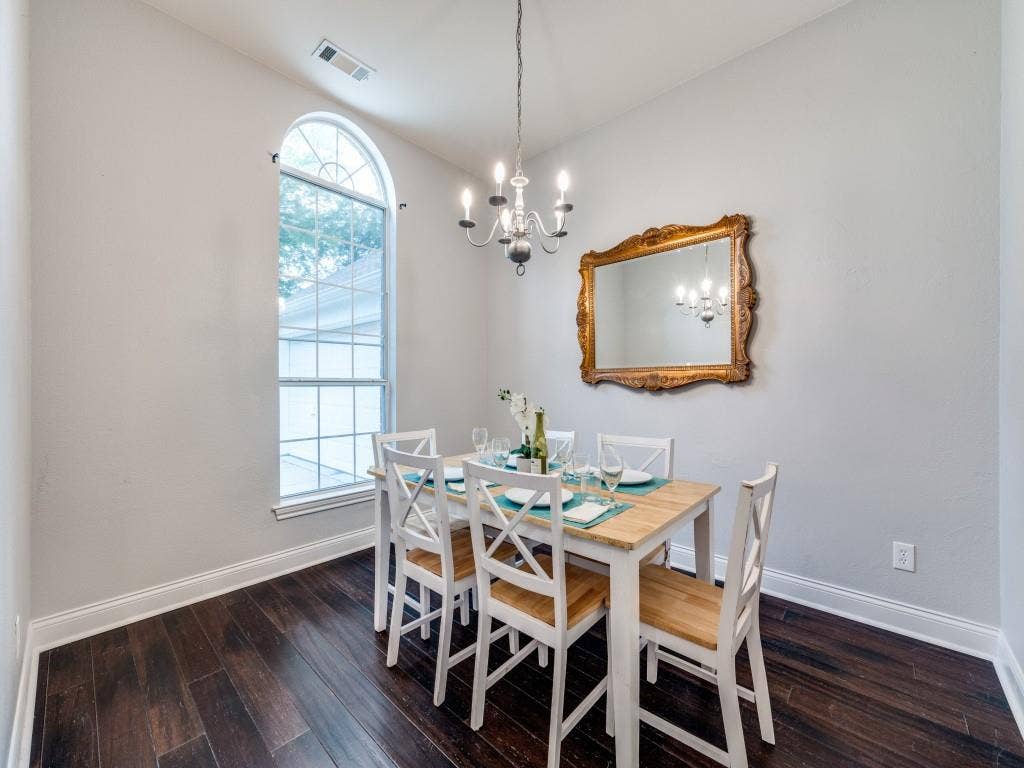 5604 Parkplace Drive, Denton, TX 76226 Arched window, wood-finish flooring, high ceilings, decorative chandelier, and crown molding