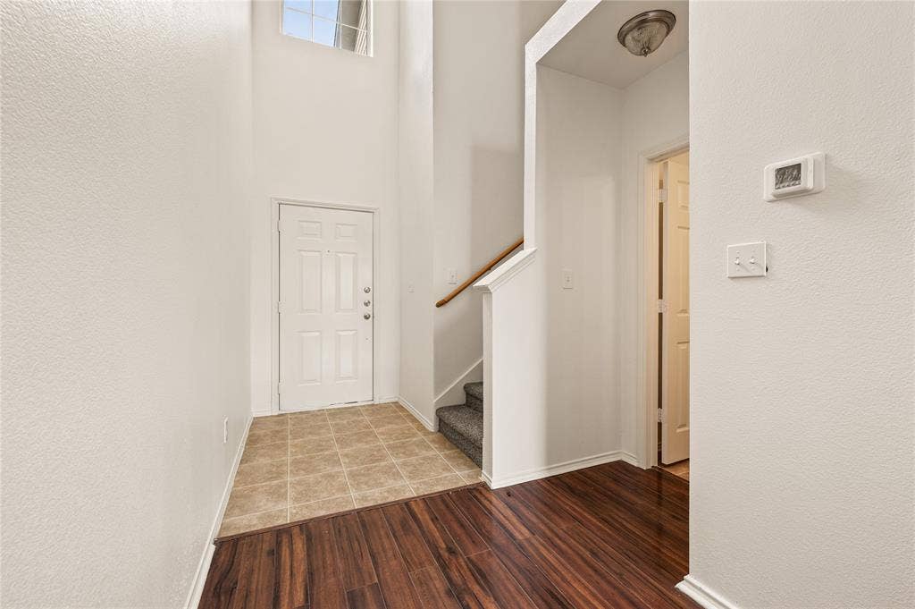 4535 Woodsboro Lane, Plano, TX 75024 Two-story foyer with a transom window, wood-finish flooring, and a tiled entry