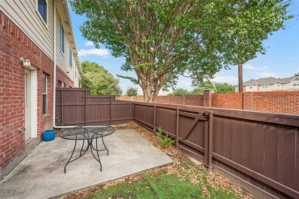 4535 Woodsboro Lane, Plano, TX 75024 Private outdoor patio with concrete paving, mature tree, and wood privacy fencing