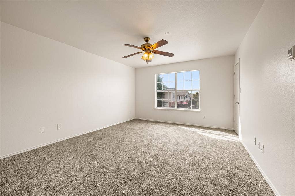 4535 Woodsboro Lane, Plano, TX 75024 Plush carpet flooring, a multi-pane window, and a ceiling fan with integrated lighting