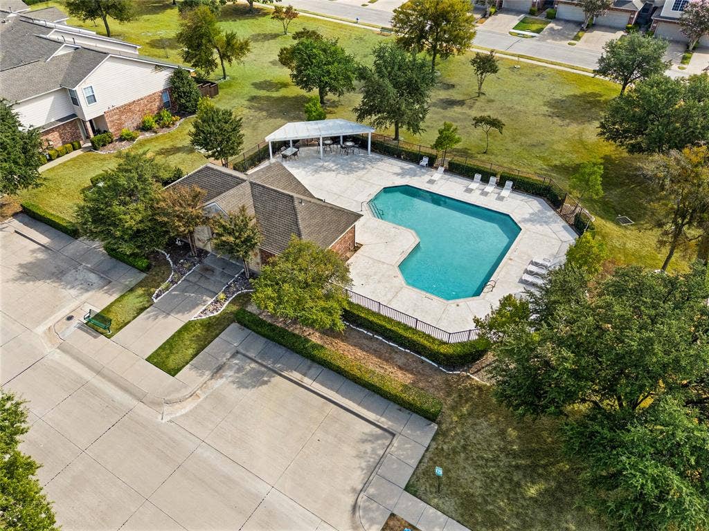 4535 Woodsboro Lane, Plano, TX 75024 Geometric-shaped pool with concrete decking, surrounding privacy fencing, and an adjacent covered cabana area