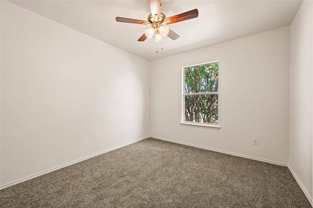 4535 Woodsboro Lane, Plano, TX 75024 Neutral tone walls, ceiling fan with light fixture, window providing natural illumination, and carpeting