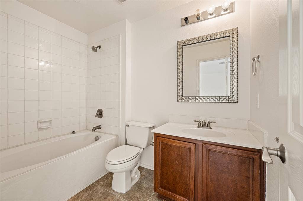 4535 Woodsboro Lane, Plano, TX 75024 White tiled tub and shower combination with oil-rubbed bronze fixtures