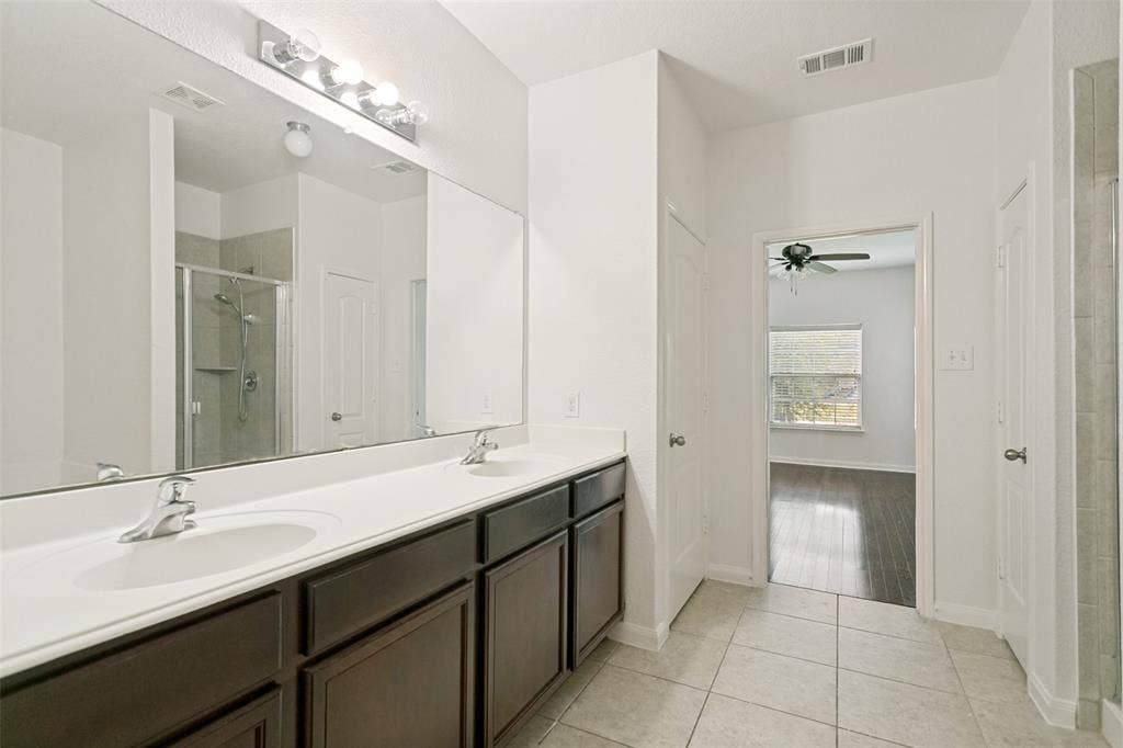 Dual vanity with undermount sinks, chrome fixtures, and dark wood-finish cabinetry