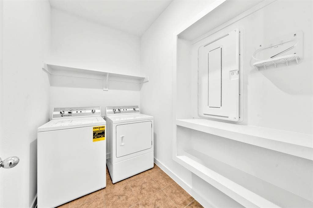 3928 Bison Lane, Crandall, TX 75114 Laundry area with a top-load washer, front-load dryer, and two wall-mounted shelves