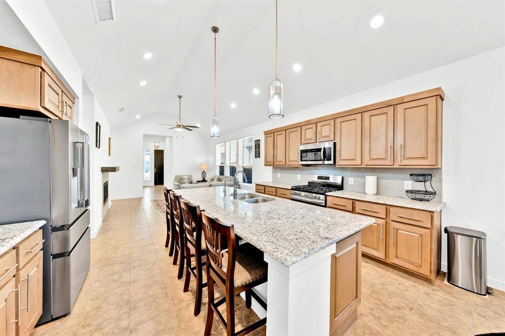 3928 Bison Lane, Crandall, TX 75114 Kitchen featuring light-tone cabinetry, stainless steel appliances, a large center island with a sink, and pendant lighting