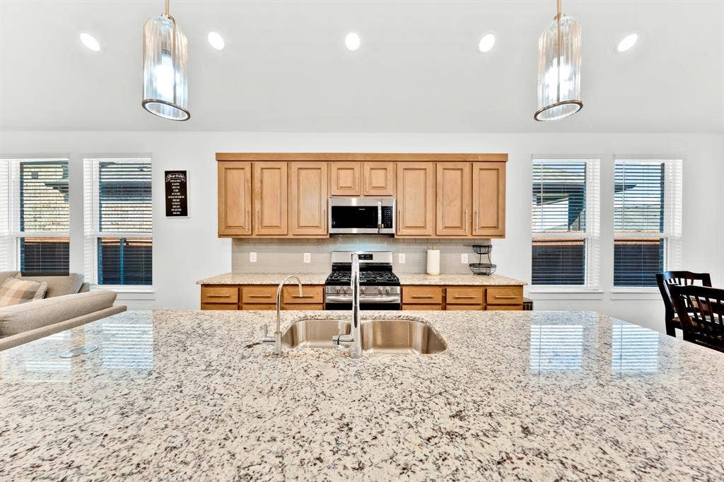 3928 Bison Lane, Crandall, TX 75114 Extended kitchen island with stone countertop and undermount sink