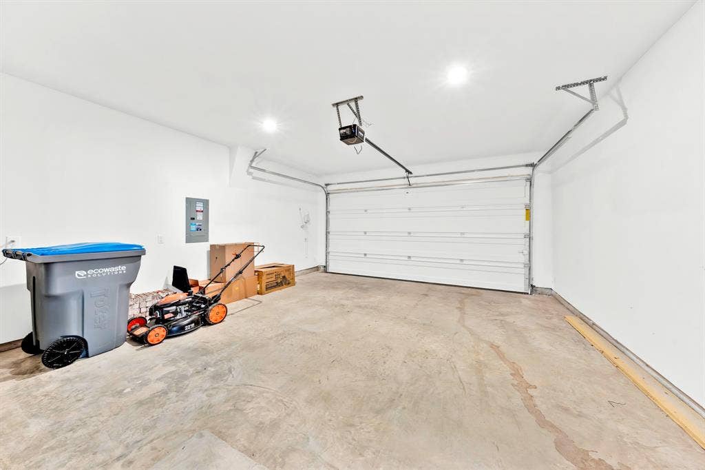 3928 Bison Lane, Crandall, TX 75114 Spacious garage with a concrete floor, white walls, and a white overhead door