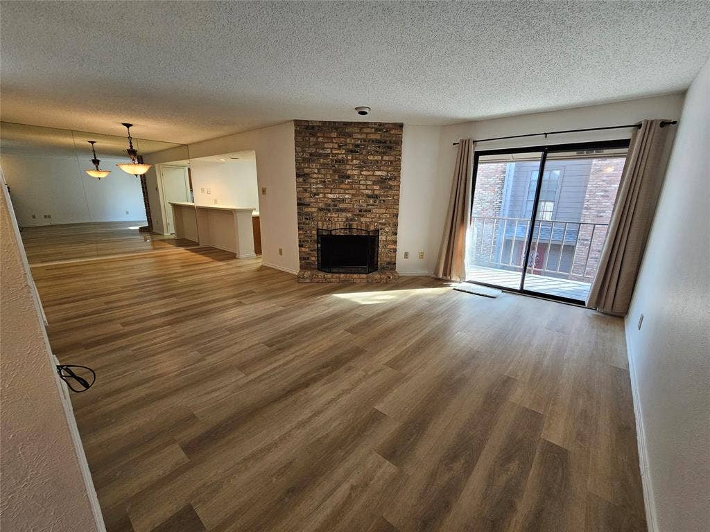 Living room featuring a brick fireplace, and balcony
