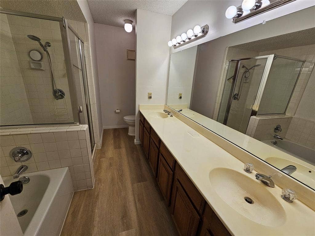 Primary bathroom featuring shower with separate bathtub and double sink vanity