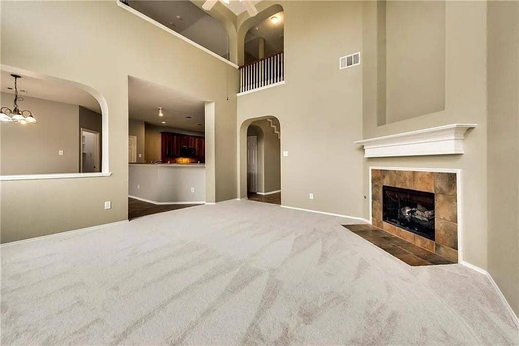 9304 Regal Oaks Drive, McKinney, TX 75072 Two-story ceilings, arched doorways, tiled fireplace, and a second-story balcony