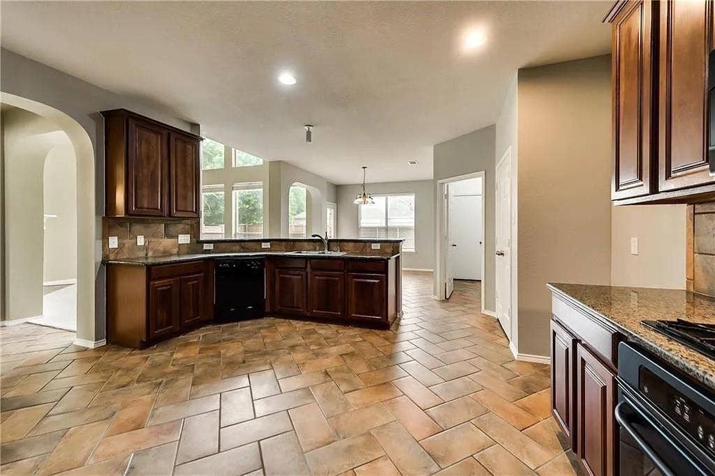 9304 Regal Oaks Drive, McKinney, TX 75072 Kitchen featuring herringbone pattern tile flooring, dark wood cabinetry, a built-in oven, and a double basin sink