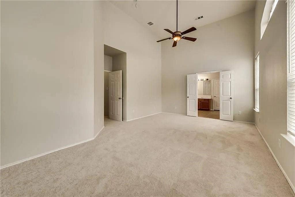 9304 Regal Oaks Drive, McKinney, TX 75072 Vaulted ceiling, ceiling fan with integrated lighting, neutral carpet, double windows with blinds, and white panel doors
