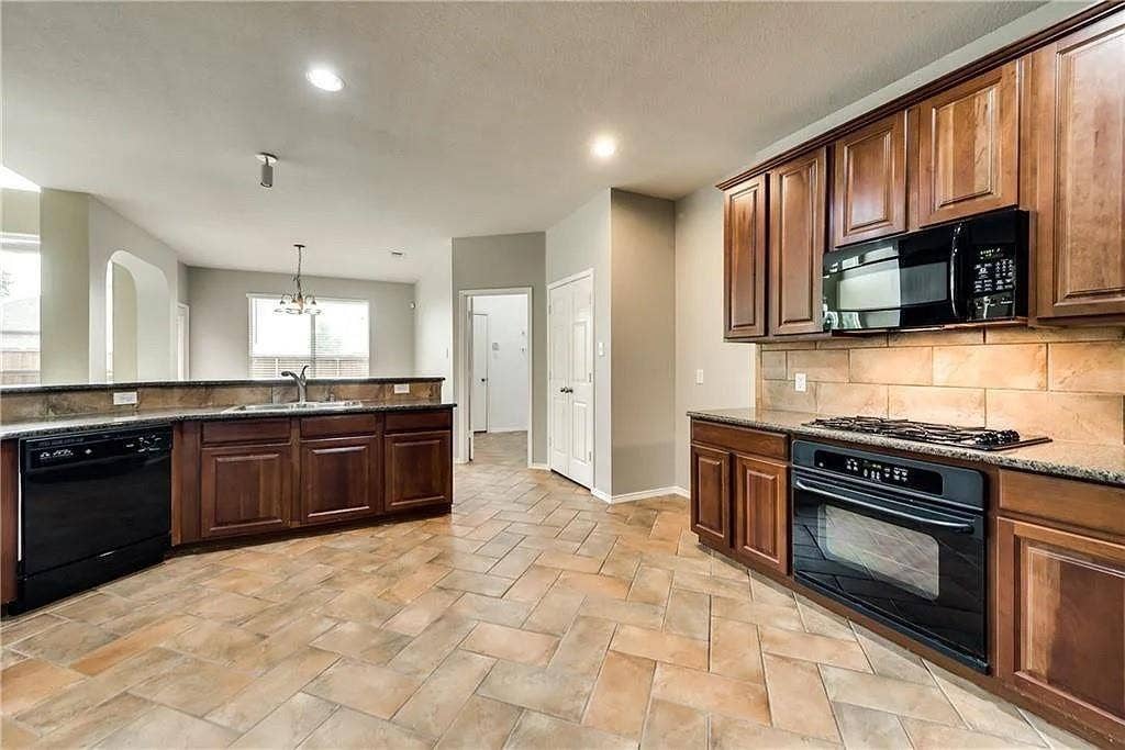 9304 Regal Oaks Drive, McKinney, TX 75072 Kitchen featuring wood cabinetry, black appliances, a tile backsplash, and tile flooring