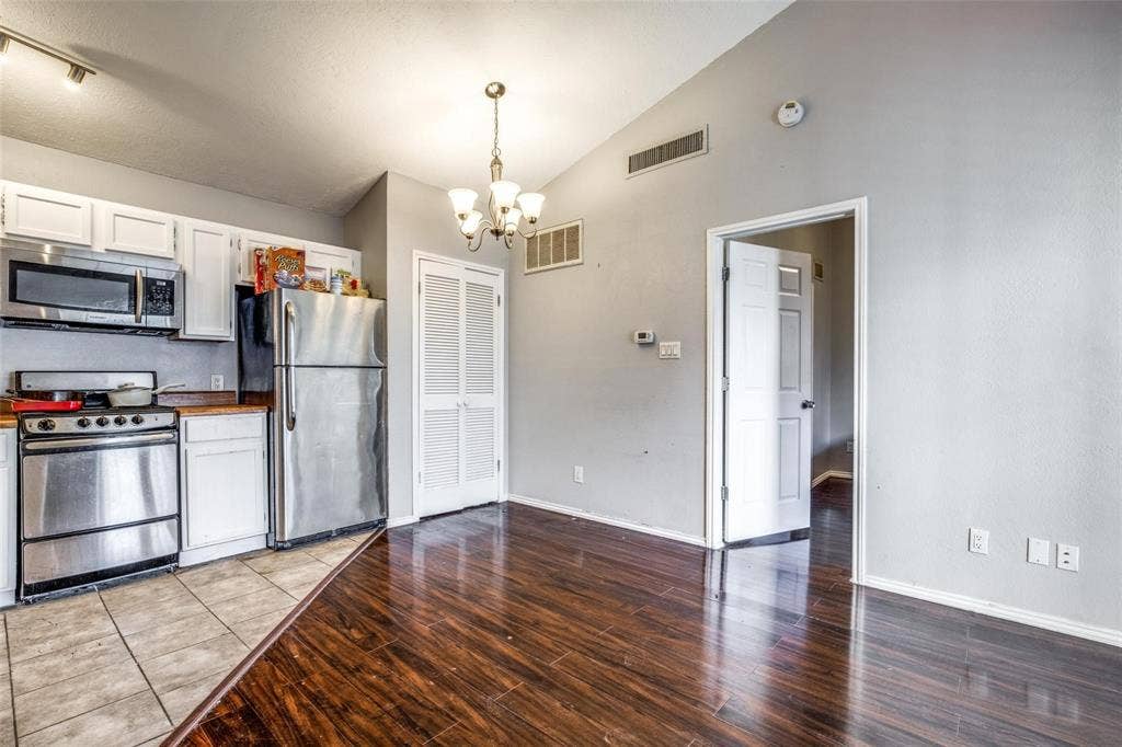 6108 Abrams Road, #118, Dallas, TX 75231 Kitchen with stainless steel appliances, white cabinetry, and wood-finish countertops