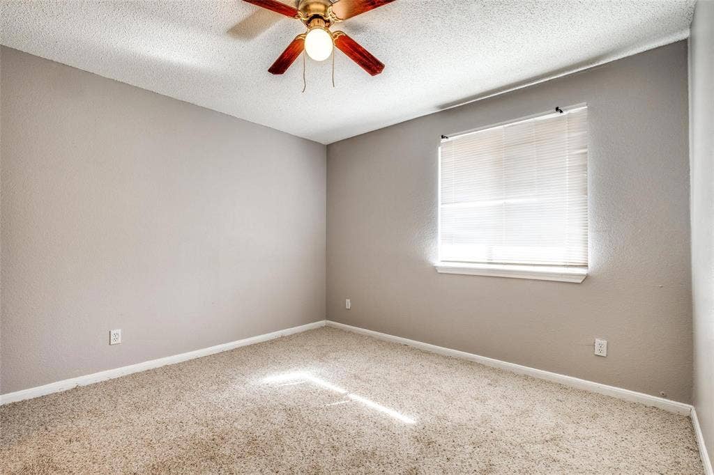 6108 Abrams Road, #118, Dallas, TX 75231 Neutral wall color, carpeted flooring, window with blinds, and a ceiling fan with integrated lighting