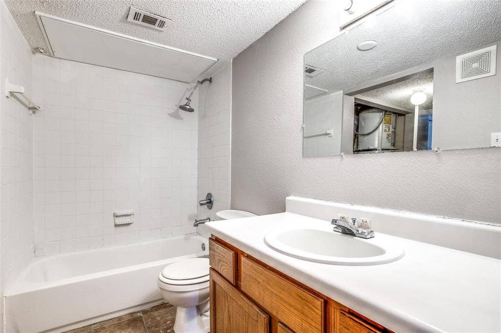 6108 Abrams Road, #118, Dallas, TX 75231 White tiled shower/tub combination with a chrome showerhead
