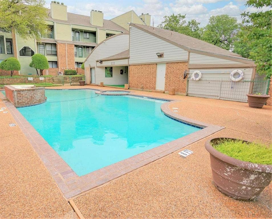 6108 Abrams Road, #118, Dallas, TX 75231 Swimming pool with integrated spa and surrounding exposed aggregate concrete decking