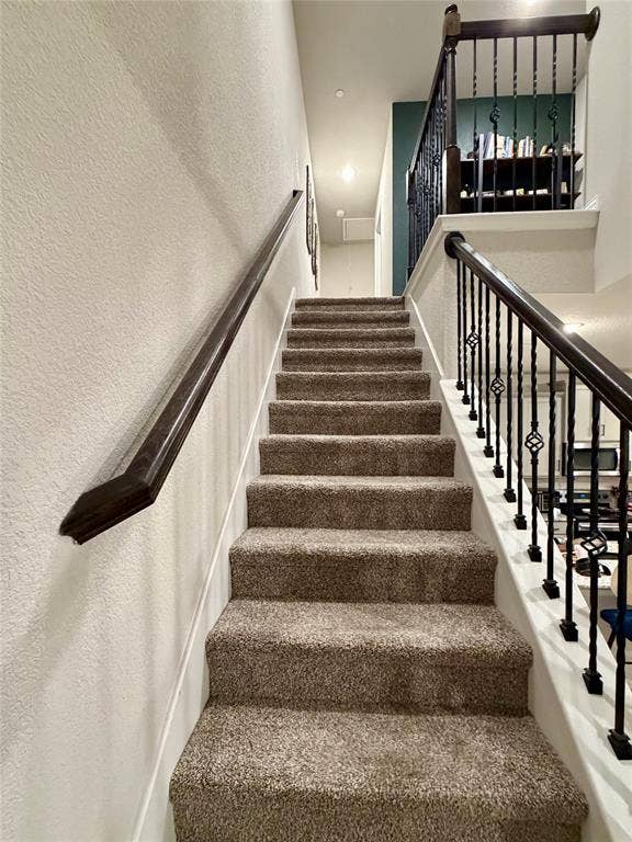 2812 Appaloosa Lane, Mesquite, TX 75150 Carpeted staircase with dark wood-finish handrails and decorative wrought iron balusters