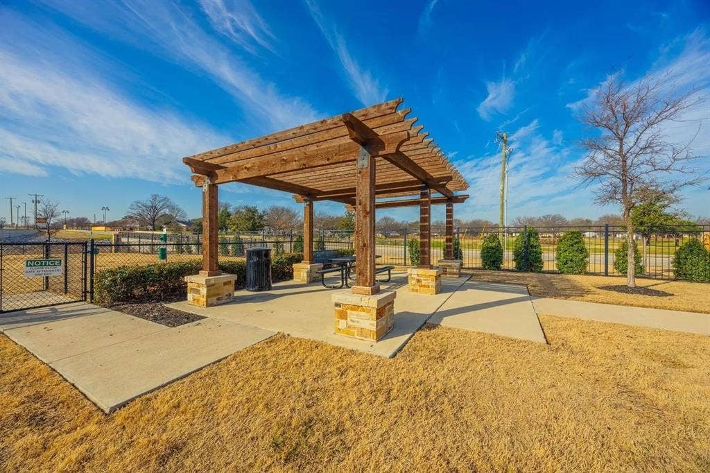 2812 Appaloosa Lane, Mesquite, TX 75150 Wood pergola with stone-clad pillars, concrete patio, and fenced perimeter
