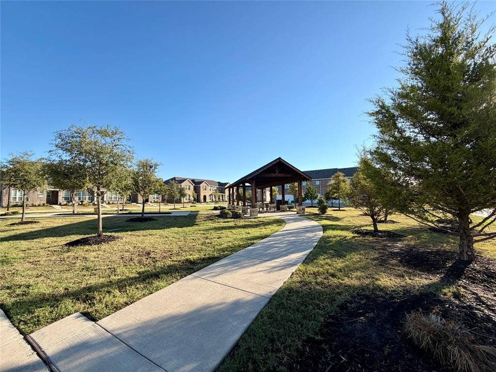 2812 Appaloosa Lane, Mesquite, TX 75150 Community green space featuring a concrete pathway, a covered pavilion with stone pillars, and multiple mature trees