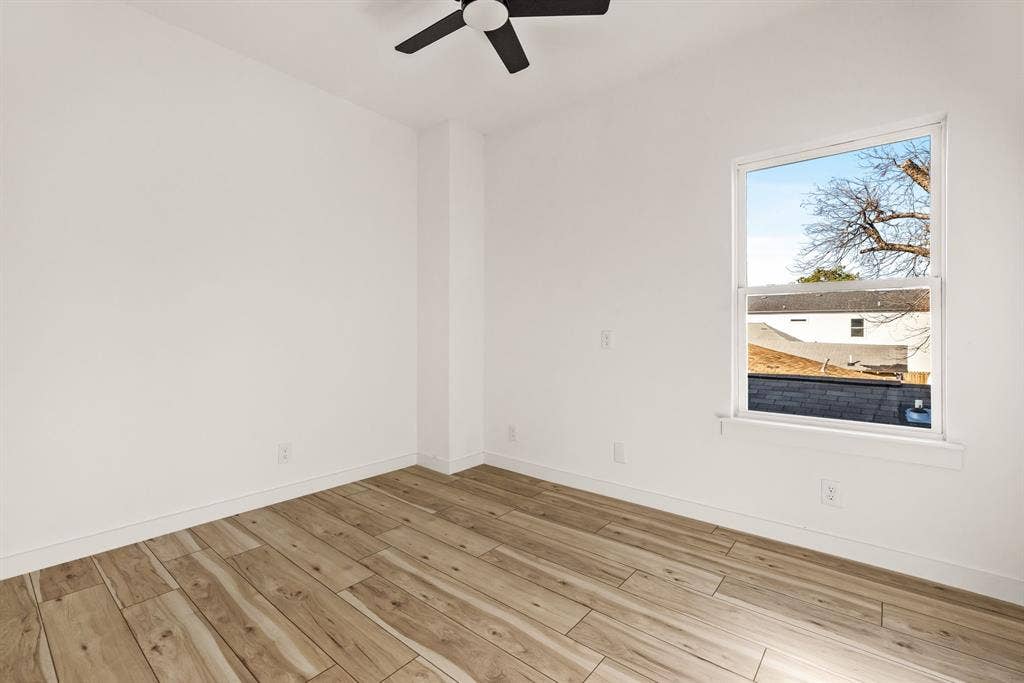 2232 Hooper Street, Dallas, TX 75215 Wood-finish flooring, white painted walls, single window, and a ceiling fan