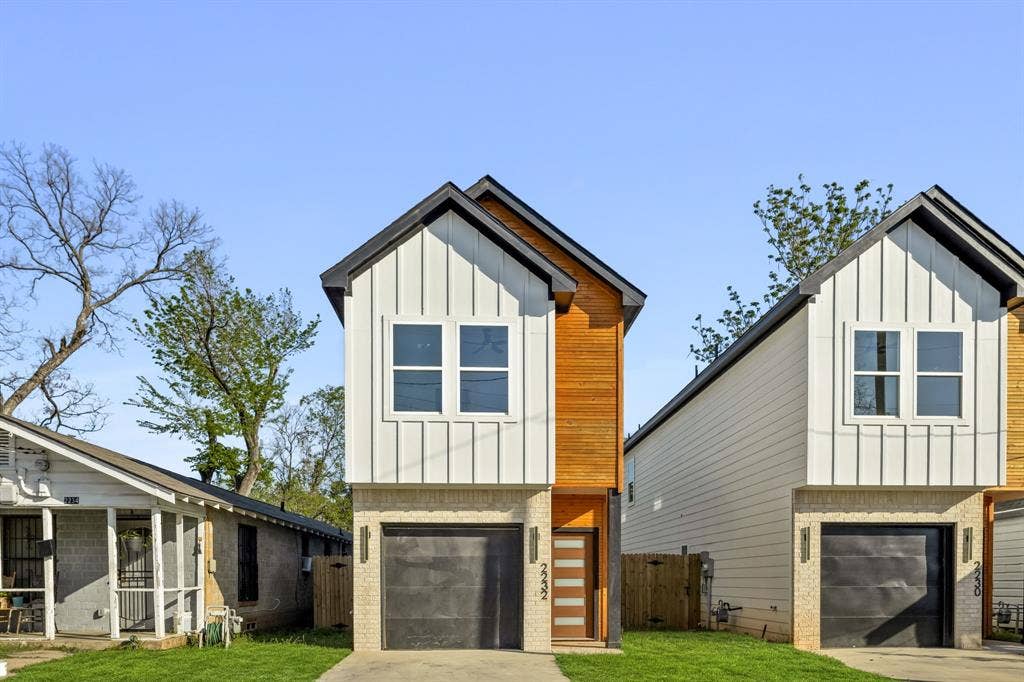 2232 Hooper Street, Dallas, TX 75215 Modern exterior with vertical white siding, natural wood panel accents, and a dark pitched roof