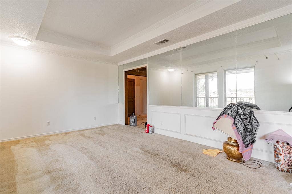 4320 Hickox Road, Rowlett, TX 75089 Recessed ceiling with crown molding, wall-mounted mirror panels, and white wainscoting