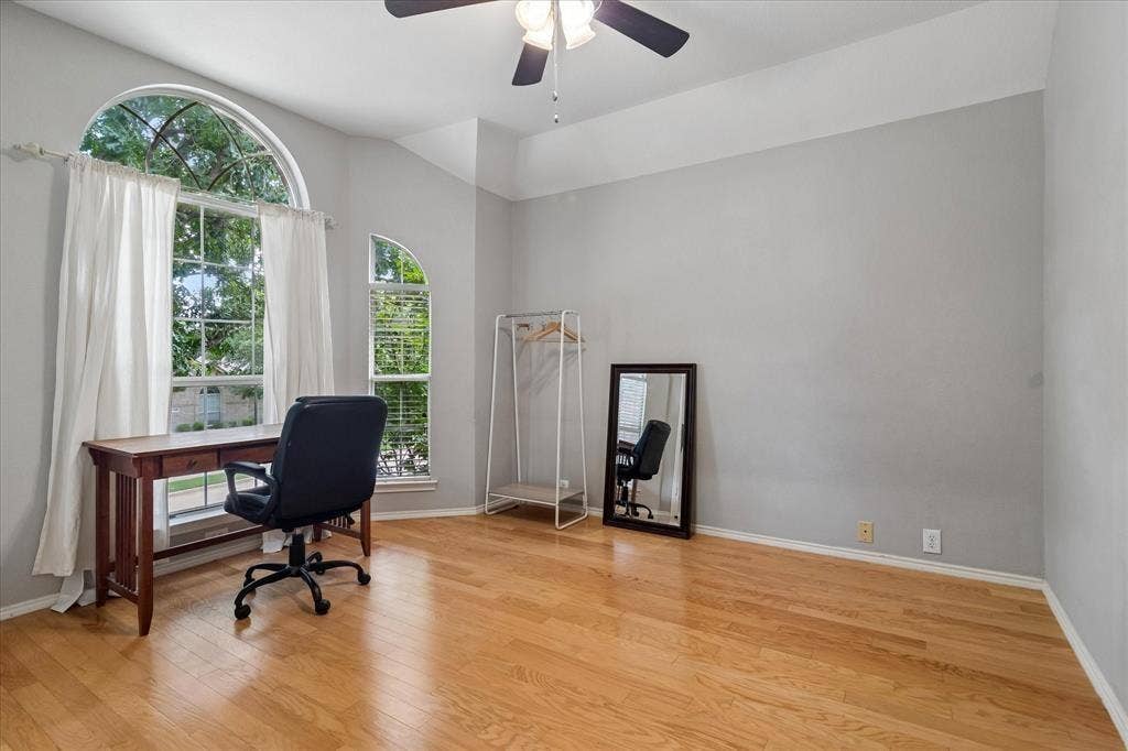 11379 Lockshire Drive, Frisco, TX 75035 Vaulted ceiling with a ceiling fan, arched windows, and wood-finish flooring