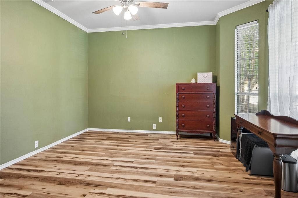 11379 Lockshire Drive, Frisco, TX 75035 Wood-finish flooring, ceiling fan with integrated lighting, crown molding, and a corner window with horizontal blinds