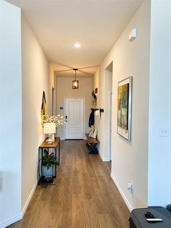 Recessed ceiling lighting, wood-finish flooring, and a pendant light fixture