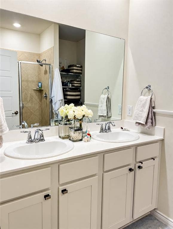 Dual undermount sinks with chrome fixtures, white countertops, and white cabinetry