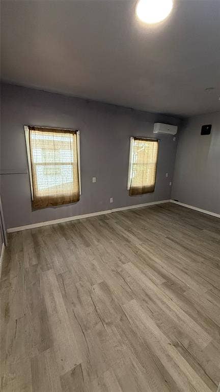 605 Biggs Terrace, Arlington, TX 76010 Light wood-finish flooring, two windows, and a wall-mounted climate control unit