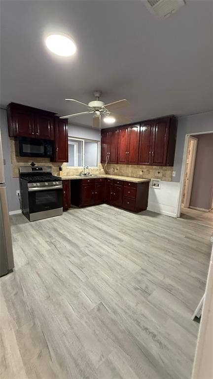 605 Biggs Terrace, Arlington, TX 76010 Kitchen featuring wood-finish flooring, dark wood cabinetry, stainless steel oven, and a tiled backsplash