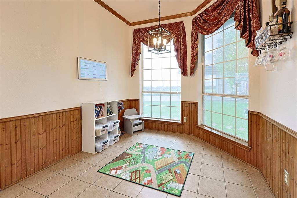 2042 County Road 1072, Greenville, TX 75401 Tile flooring, wood wainscoting, floor-to-ceiling windows, and a geometric metal pendant light fixture