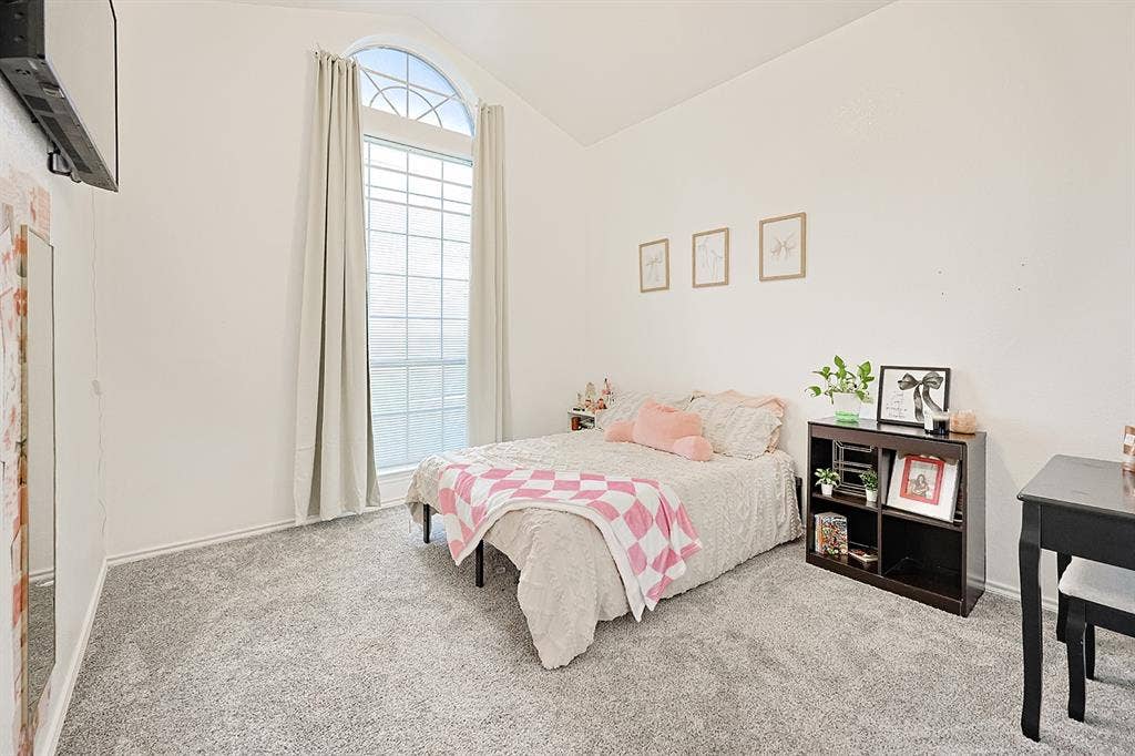 2042 County Road 1072, Greenville, TX 75401 Vaulted ceiling featuring a tall, arched multi-pane window with neutral wall-to-wall carpeting