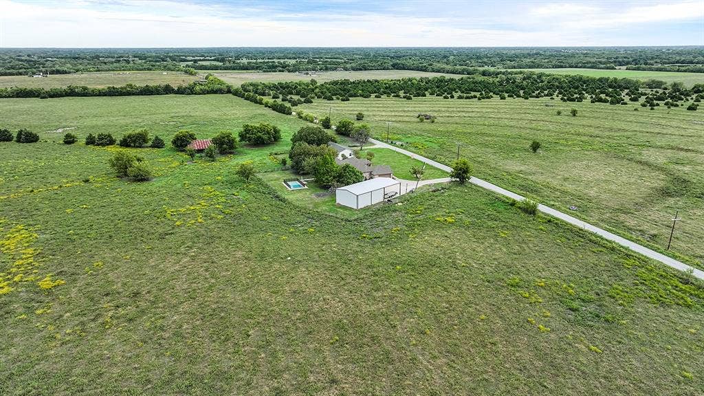 2042 County Road 1072, Greenville, TX 75401 Expansive acreage featuring a private swimming pool, detached metal structure, and paved driveway