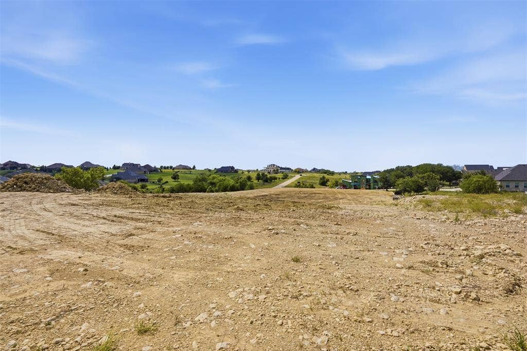 12300 Bella Quinn Drive, Fort Worth, TX 76126 Expansive land parcel featuring cleared terrain and distant neighborhood structures