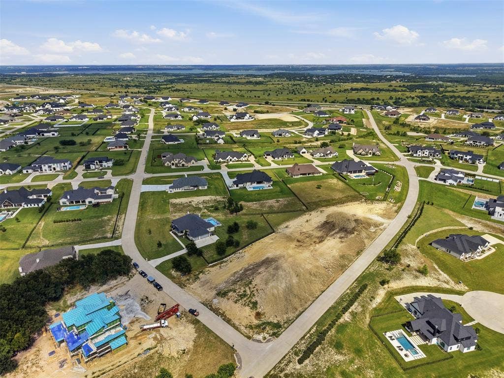 12300 Bella Quinn Drive, Fort Worth, TX 76126 Expansive residential development with paved roadways, abundant green space, and a distant natural landscape