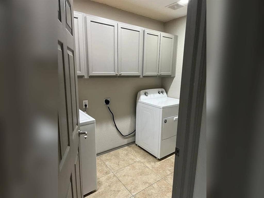 2500 Sierra Drive, McKinney, TX 75071 Laundry space featuring upper cabinetry, tile flooring, and integrated wall outlets