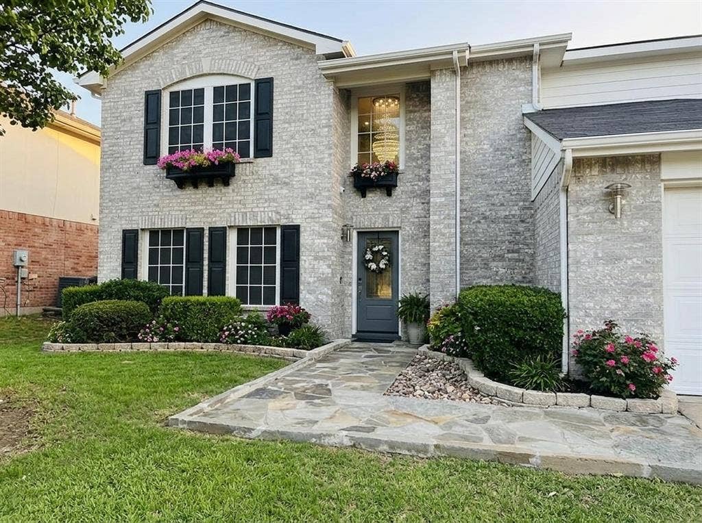 2500 Sierra Drive, McKinney, TX 75071 Two-story brick exterior with dark shutters, stone walkway, and established landscaping